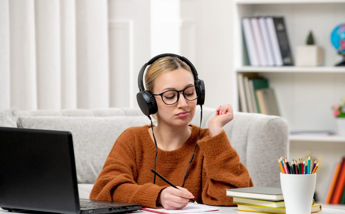 student-online-cute-girl-glasses-sweater-studying-computer-taking-down-notes (1)